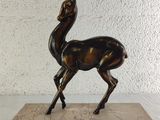 statue of a gazelle on a marble base on a white background