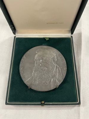 une image représentant une médaille d'argent dans un coffret posé sur une surface blanche