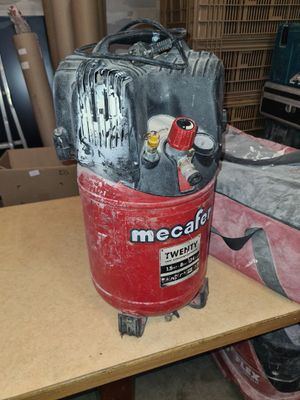 a red and black air compressor sitting on top of a wooden table