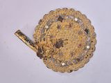 brass plate with a handle on a white surface