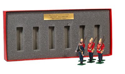 three figurines of soldiers standing in front of a red box