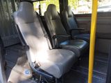 three seats in the back of a bus that are empty