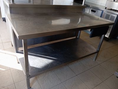 a large stainless steel table in the middle of a kitchen