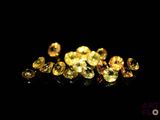 a pile of yellow diamonds on a black surface