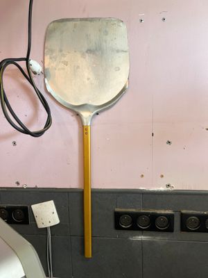 une grande spatule accrochée au mur d'une salle de bains