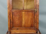 un vieux meuble en bois surmonté d'une porte en verre