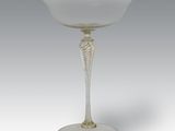 une image représentant un verre à vin blanc posé sur un socle en argent