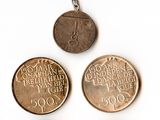 four different coins are shown on a keychain on a white surface