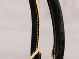 a close up of a black and gold handbag on a white background