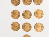 several gold coins are arranged in a row on a white surface
