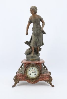 une statue représentant une femme debout au sommet d'une horloge