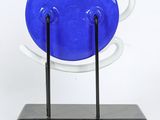 a blue and white plate on a stand on a white background