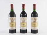 three bottles of wine are lined up on a white surface