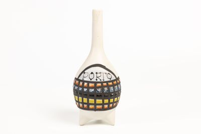 un vase blanc orné d'un motif noir et orange