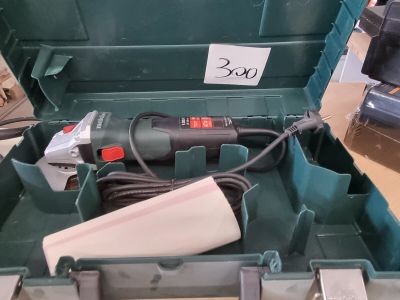 un outil dans une boîte verte sur laquelle est accrochée une étiquette de prix