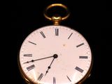 une montre de poche en or avec des chiffres romains sur le cadran