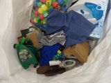 a white bag filled with assorted items on a bed