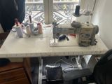 une machine à coudre posée sur une table devant une fenêtre