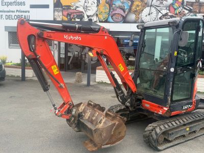 an image of a small excavator parked in a parking lot