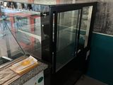 a counter with a glass display case in a restaurant