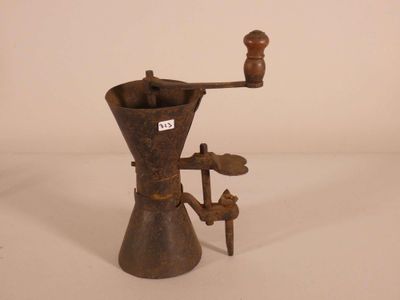 un vieux moulin à café posé sur une surface blanche