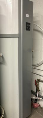 a water heater in the corner of a room next to a toilet