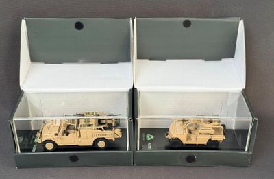 deux véhicules militaires exposés dans une vitrine posée sur une table