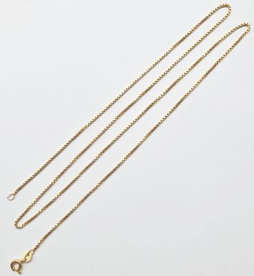 une paire de colliers en chaîne en or sur fond blanc