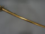 an old gold sword with a metal handle on a white surface