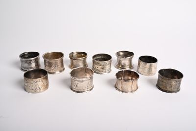 six ronds de serviette en argent posés sur une surface blanche, sur fond blanc