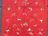 une vieille couette chinoise en soie rouge et blanche, ornée d'oiseaux et de fleurs