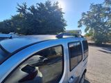 a silver car parked in a parking lot with trees in the background
