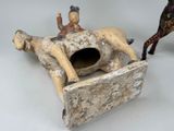 a figurine of a man riding a horse on a bed