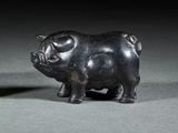 une petite statue représentant un cochon, posée sur une table
