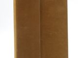 two brown books sitting on top of each other on a white surface