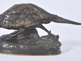 a bronze statue of a pheasant on top of a rock