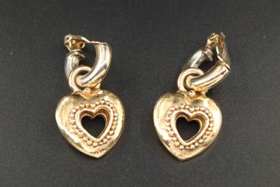 paire de boucles d'oreilles dorées en forme de cœur sur fond noir