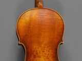 an old violin with a wooden back and bow on a gray background