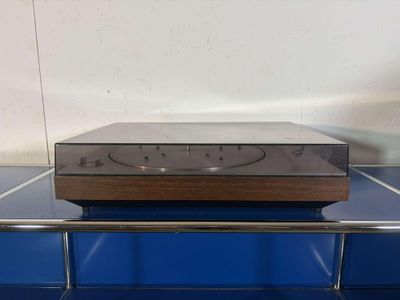 an old stereo player sitting on top of a blue shelf
