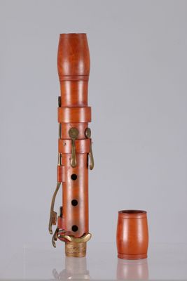an old wooden pipe with a metal holder and a cup on a table