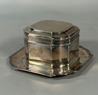 a silver plate with a silver lid and a silver tray on it