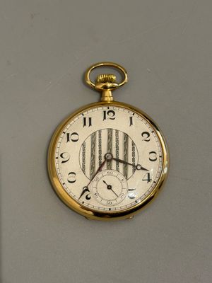 une montre de poche en or accrochée au mur