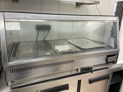 stainless steel counter top with a glass display case in a commercial kitchen