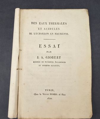 an open book sitting on top of a table next to a black table