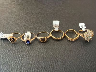 five different rings are lined up in a row on a table