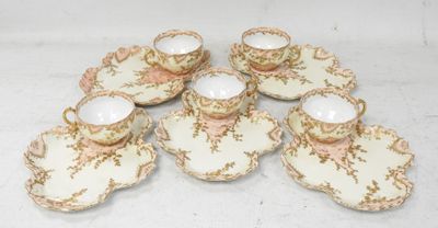 six tasses et soucoupes sont posées sur une surface blanche