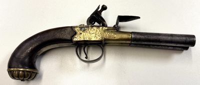 un pistolet accroché au mur, sur lequel est assis un homme