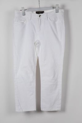 a white pants hanging on a hanger against a white wall