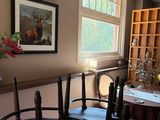 a table and chairs in a room with a picture on the wall