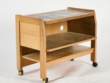 a small wooden table with a tile top on wheels